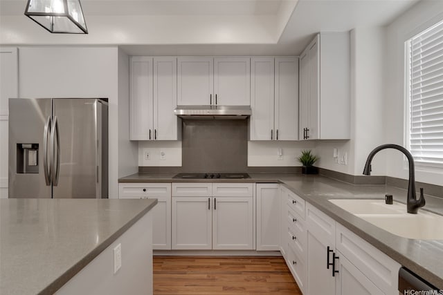 91-1067 Hoomahana St, Ewa Beach, HI 96706 - kitchen with stainless steel fridge with ice dispenser, a sink, under cabinet range hood, black electric stovetop, and light wood finished floors