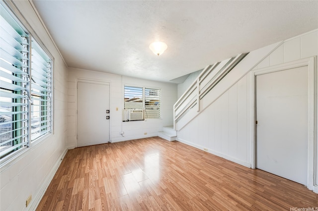713 Menehune Ln, Honolulu, HI 96826 - entryway featuring light wood-style floors, a textured ceiling, a decorative wall, and cooling unit