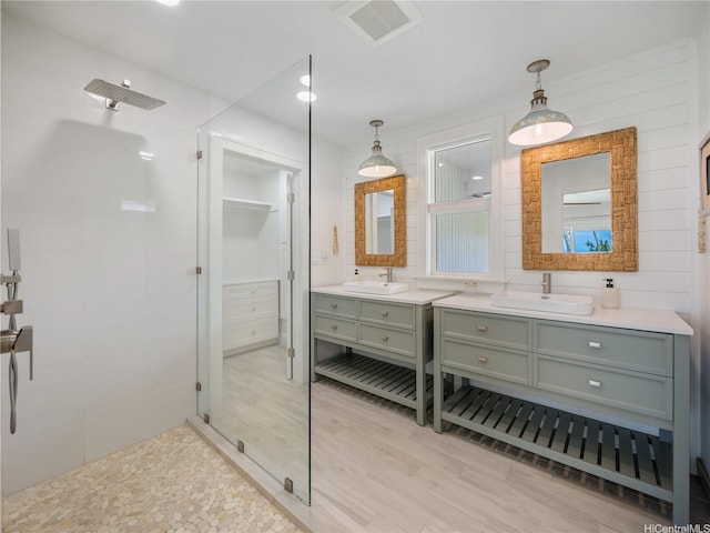 6173 Summer St, Honolulu, HI 96821 - bathroom featuring a tile shower, two vanities, wood finished floors, and recessed lighting