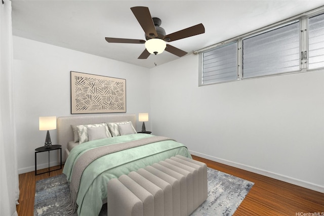 bedroom with baseboards, wood finished floors, and a ceiling fan