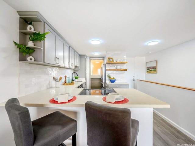 68-024 Apuhihi St Unit W511, Waialua, HI 96791 - kitchen featuring open shelves, black electric stovetop, light countertops, and a peninsula