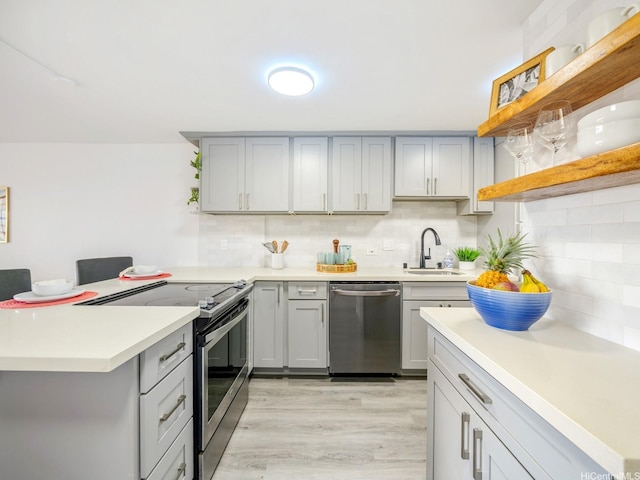 68-024 Apuhihi St Unit W511, Waialua, HI 96791 - kitchen with open shelves, stainless steel appliances, gray cabinetry, a peninsula, and light wood-style flooring