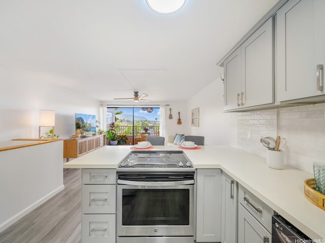 68-024 Apuhihi St Unit W511, Waialua, HI 96791 - kitchen featuring stainless steel electric stove, a peninsula, light wood-type flooring, backsplash, and light countertops