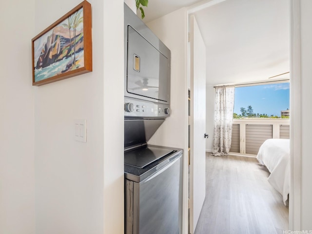 68-024 Apuhihi St Unit W511, Waialua, HI 96791 - laundry room featuring stacked washing machine and dryer and wood finished floors