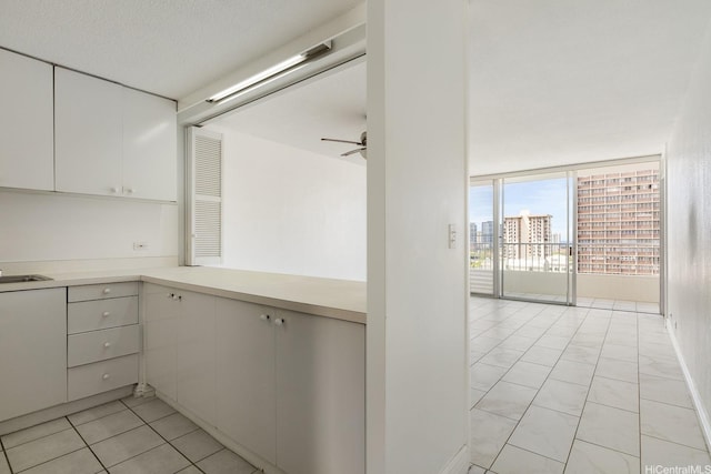 1515 Ward Ave Unit 304, Honolulu, HI 96822 - kitchen featuring white cabinets, light countertops, ceiling fan, and floor to ceiling windows