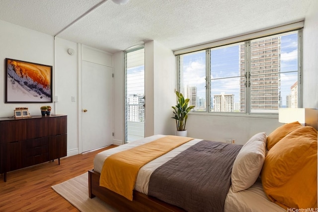 1515 Ward Ave Unit 304, Honolulu, HI 96822 - bedroom with wood finished floors, a textured ceiling, and multiple windows