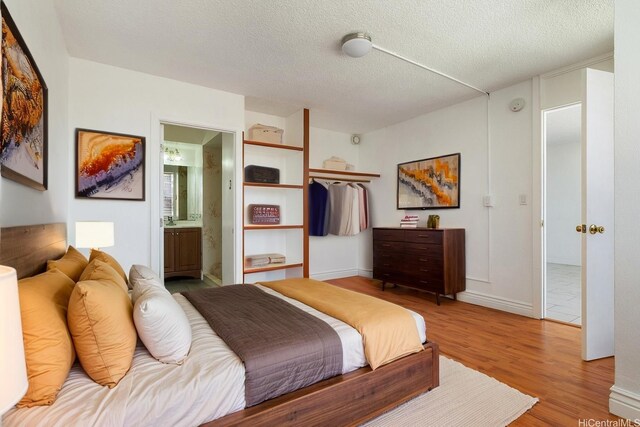 1515 Ward Ave Unit 304, Honolulu, HI 96822 - bedroom with wood finished floors, a textured ceiling, and ensuite bath