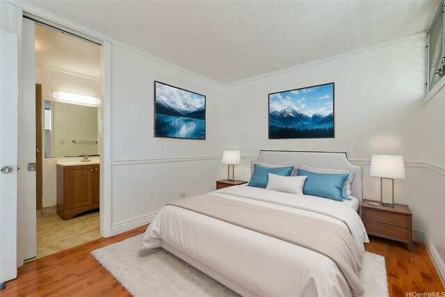 1515 Ward Ave Unit 304, Honolulu, HI 96822 - bedroom with light wood-style flooring, ornamental molding, connected bathroom, and a sink