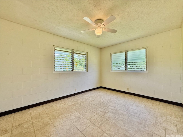 61-286 Kamehameha Hwy, Haleiwa, HI 96712 - spare room with ceiling fan, a textured ceiling, stone finish flooring, concrete block wall, and baseboards