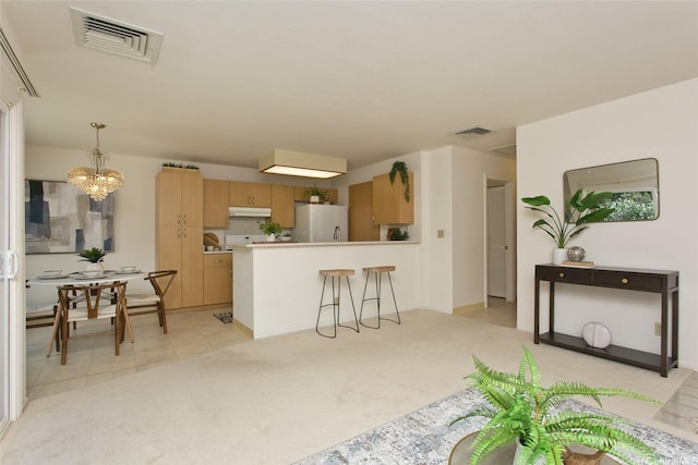 98-1970-A Kaahumanu St Unit 128, Pearl City, HI 96782 - kitchen featuring freestanding refrigerator, under cabinet range hood, a peninsula, a chandelier, and light countertops