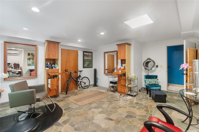 living area featuring stone floors, recessed lighting, and a wall mounted AC