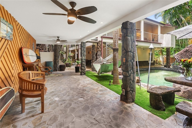 view of patio featuring a ceiling fan and a balcony