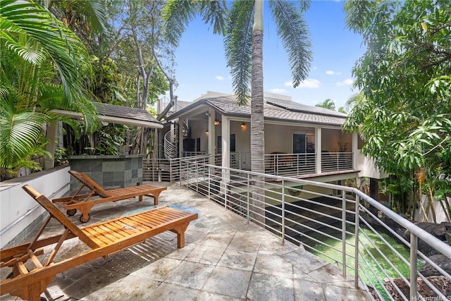 view of front of property with roof mounted solar panels and stucco siding