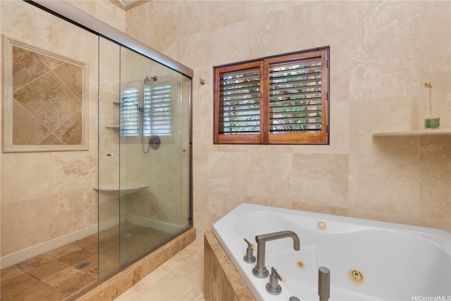 full bath featuring a stall shower, a whirlpool tub, and tile walls