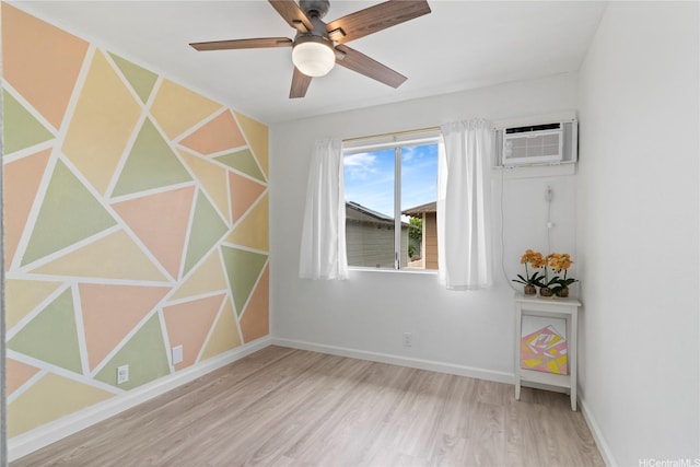 91-1043 Hoomaka St Unit 48, Ewa Beach, HI 96706 - spare room featuring wood finished floors, an AC wall unit, ceiling fan, and baseboards