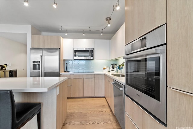 888 Kapiolani Blvd Unit 2108, Honolulu, HI 96813 - kitchen featuring appliances with stainless steel finishes, light brown cabinets, modern cabinets, a sink, and backsplash