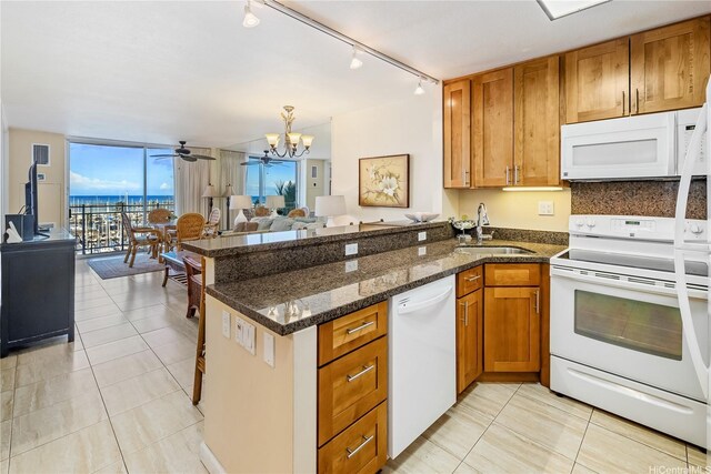 1765 Ala Moana Blvd Unit 790, Honolulu, HI 96815 - kitchen featuring white appliances, a sink, open floor plan, a peninsula, and brown cabinets