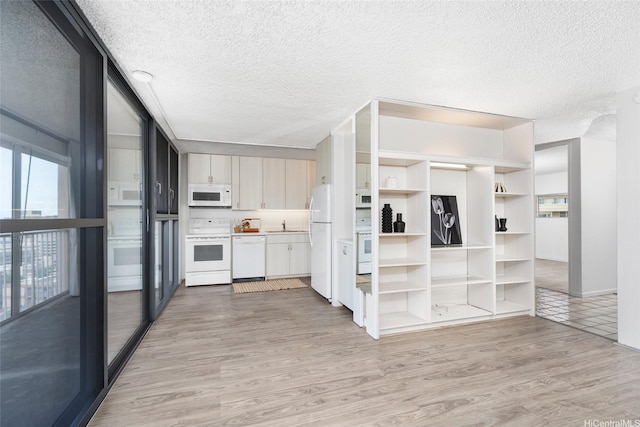1520 Ward Ave Unit 802, Honolulu, HI 96822 - kitchen with white appliances, a textured ceiling, light wood finished floors, light countertops, and a sink