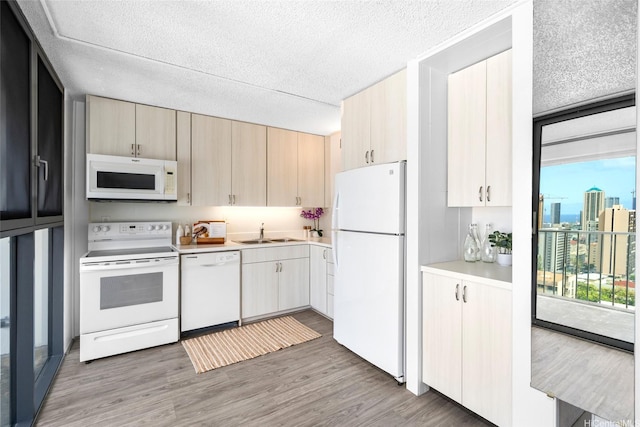 1520 Ward Ave Unit 802, Honolulu, HI 96822 - kitchen with white appliances, a sink, light countertops, light wood-style floors, and a textured ceiling