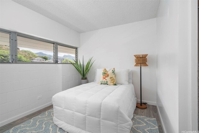 1520 Ward Ave Unit 802, Honolulu, HI 96822 - bedroom featuring wood finished floors, a textured ceiling, and baseboards