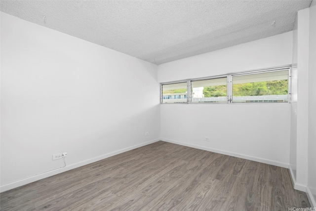 1520 Ward Ave Unit 802, Honolulu, HI 96822 - empty room featuring wood finished floors, a textured ceiling, and baseboards