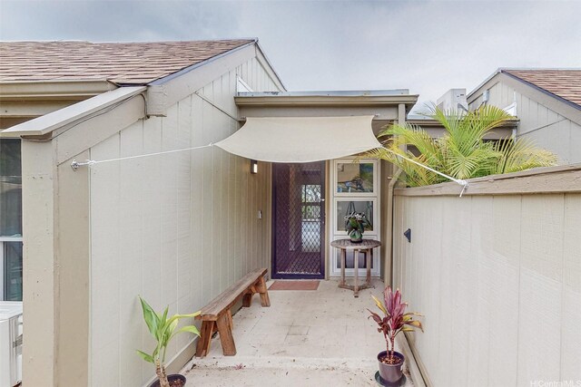 44-3082 Olina St Unit 5/2, Kaneohe, HI 96744 - view of exterior entry featuring a shingled roof, fence, and a patio