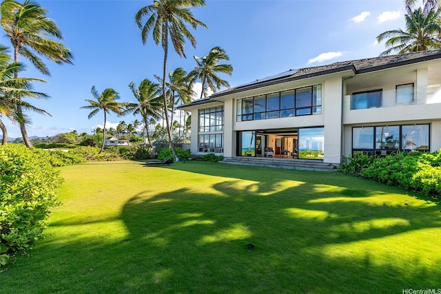 572C N Kalaheo Ave, Kailua, HI 96734 - rear view of house featuring stucco siding, solar panels, and a yard