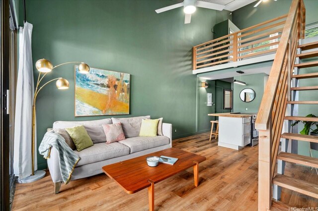 51-636 Kamehameha Hwy Unit 323, Kaaawa, HI 96730 - living area featuring a towering ceiling, stairs, a ceiling fan, light wood finished floors, and baseboards