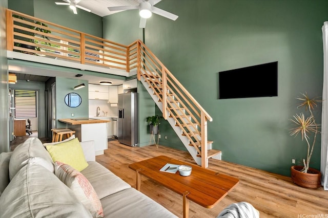 51-636 Kamehameha Hwy Unit 323, Kaaawa, HI 96730 - living area featuring ceiling fan, stairway, light wood-style flooring, and a high ceiling