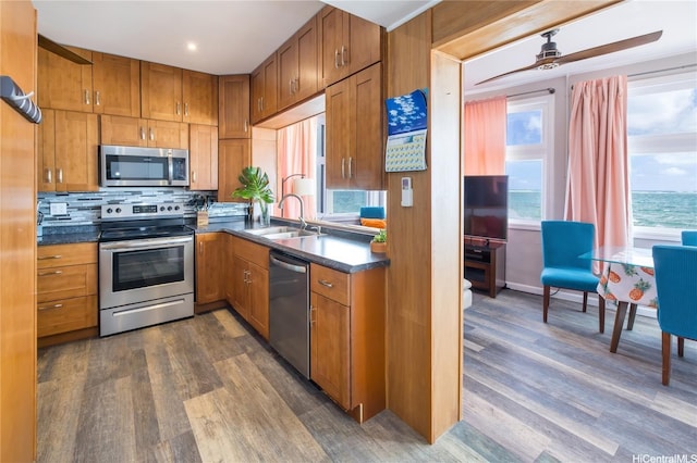 53-797 Kamehameha Hwy, Hauula, HI 96717 - kitchen featuring stainless steel appliances, a sink, brown cabinets, dark countertops, and dark wood-type flooring
