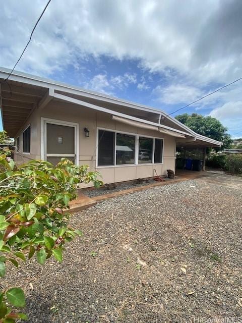 94-549 Pilimai St, Waipahu, HI 96797 - rear view of property featuring an attached carport and gravel driveway