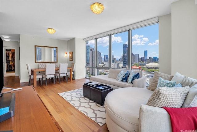 1189 Waimanu St Unit 1606, Honolulu, HI 96814 - living area with a view of skyline, wood finished floors, and a wall of windows