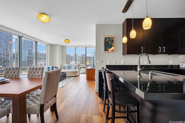 1189 Waimanu St Unit 1606, Honolulu, HI 96814 - kitchen with light wood finished floors, open floor plan, hanging light fixtures, a city view, and floor to ceiling windows