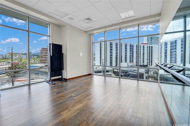 1189 Waimanu St Unit 1606, Honolulu, HI 96814 - spare room with a city view, floor to ceiling windows, wood finished floors, and a paneled ceiling