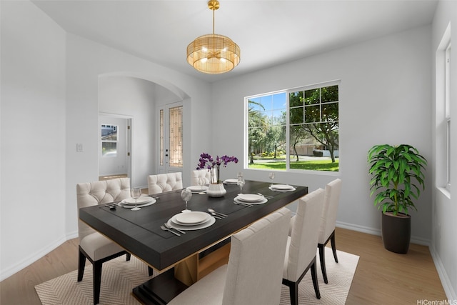 91-1023 Kaikoele St, Ewa Beach, HI 96706 - dining space with arched walkways, light wood-style flooring, a chandelier, and baseboards