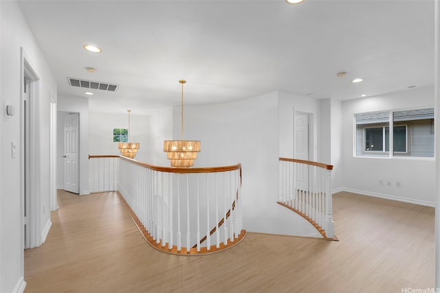 91-1023 Kaikoele St, Ewa Beach, HI 96706 - hall with an upstairs landing, a chandelier, wood finished floors, recessed lighting, and baseboards