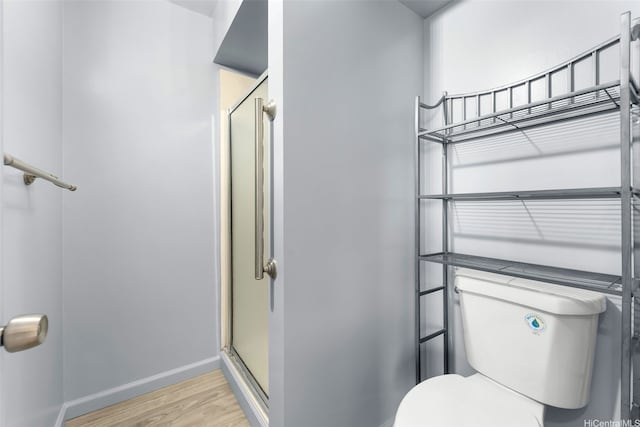 3020 Ala Napuaa Pl Unit 103, Honolulu, HI 96818 - bathroom featuring wood finished floors, a stall shower, toilet, and baseboards