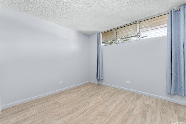 3020 Ala Napuaa Pl Unit 103, Honolulu, HI 96818 - unfurnished room with wood finished floors, a textured ceiling, and baseboards