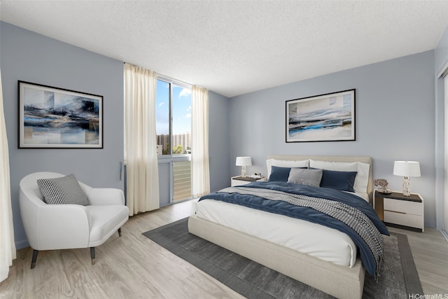 3020 Ala Napuaa Pl Unit 103, Honolulu, HI 96818 - bedroom featuring light wood-style flooring and a textured ceiling