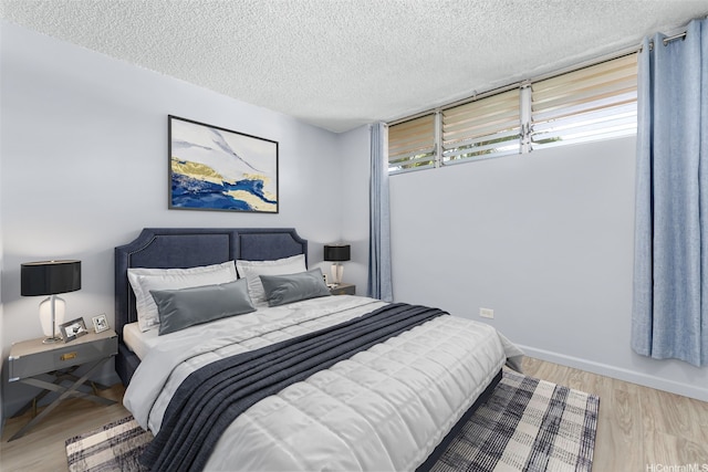 3020 Ala Napuaa Pl Unit 103, Honolulu, HI 96818 - bedroom featuring a textured ceiling, wood finished floors, and baseboards