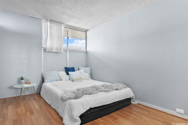 419A Atkinson Dr Unit 1203, Honolulu, HI 96814 - bedroom featuring wood finished floors, a textured ceiling, and baseboards