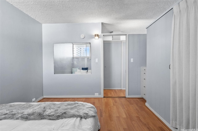419A Atkinson Dr Unit 1203, Honolulu, HI 96814 - bedroom with wood finished floors, a textured ceiling, and baseboards