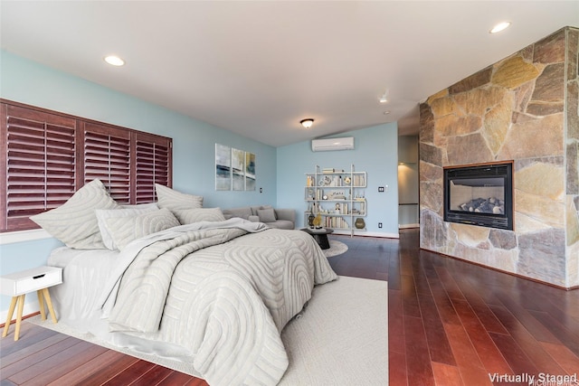 91-701B Oneula Pl, Ewa Beach, HI 96706 - bedroom with a wall unit AC, vaulted ceiling, dark wood finished floors, a stone fireplace, and baseboards