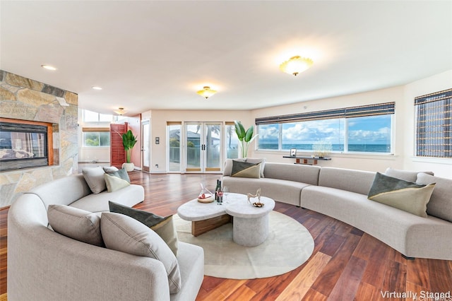 91-701B Oneula Pl, Ewa Beach, HI 96706 - living room with wood finished floors, plenty of natural light, a stone fireplace, recessed lighting, and french doors