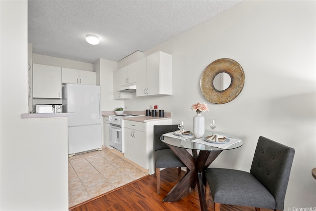 3161 Ala Ilima St Unit 1006, Honolulu, HI 96818 - kitchen with white appliances, under cabinet range hood, white cabinets, light countertops, and a textured ceiling