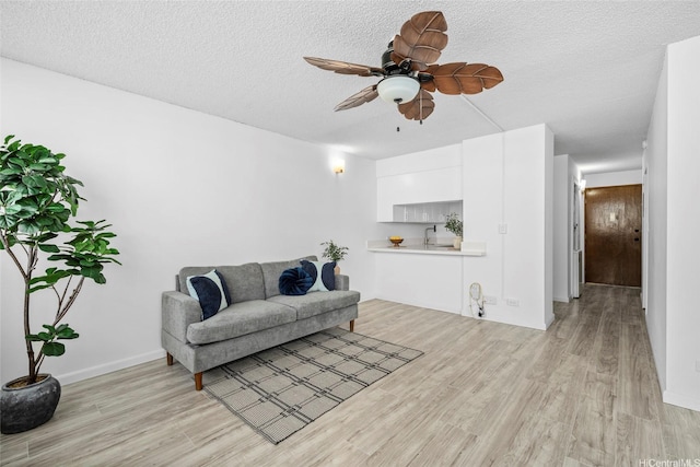 1571 Piikoi St Unit 503, Honolulu, HI 96822 - living room with light wood-style floors, a ceiling fan, a textured ceiling, and baseboards