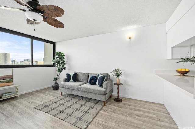 1571 Piikoi St Unit 503, Honolulu, HI 96822 - living room featuring light wood-type flooring, a ceiling fan, baseboards, a view of city, and a textured ceiling