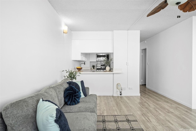 1571 Piikoi St Unit 503, Honolulu, HI 96822 - living area with light wood finished floors, ceiling fan, a textured ceiling, and baseboards