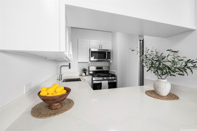 1571 Piikoi St Unit 503, Honolulu, HI 96822 - kitchen featuring appliances with stainless steel finishes, a sink, white cabinets, and light stone counters