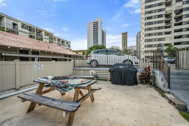 1571 Piikoi St Unit 503, Honolulu, HI 96822 - view of patio with a grill, fence, a view of city, and outdoor dining area